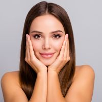 Close-up portrait of her she nice-looking attractive lovely charming feminine confident straight-haired girl touching face collagen botox nourishing isolated over gray pastel color background